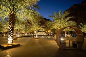 einen Innenhof mit Palmen in der Nacht und Lichtern in der Unterkunft Sahary Al Ula Resort in Al-'Ula