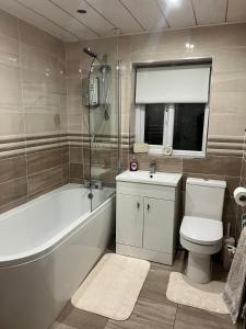 a bathroom with a toilet and a tub and a sink at Pats Place in Liverpool