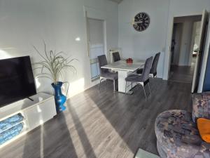 un soggiorno con tavolo, sedie e orologio di Gemütliches Gästehaus in ruhiger Waldlage a Büdingen Altre 10 foto