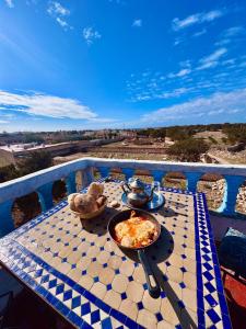 a plate of pizza on a table on a balcony at Global Surf GuestHouse in Sidi Kaouki