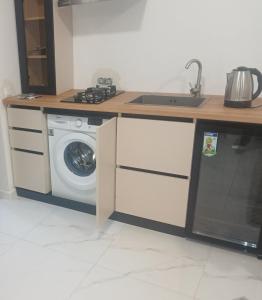 een keuken met een wasmachine en een wastafel bij Hotel SLY in Goris