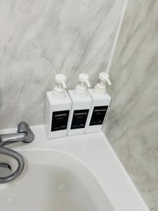 three bottles ofodorizers sitting on top of a white sink at The Luxe Haven Penthouse - Sleeps 4 Apartment Nottingham City Centre in Nottingham +19 photos