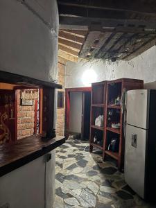 a kitchen with a refrigerator and a stone floor at Cabaña Privada Pachamama Ancestral in Medellín