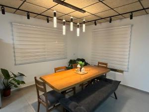a dining room with a wooden table and chairs at Country breeze park in Majdal Shams