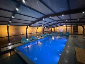 a large swimming pool with blue water in a building at Country breeze park in Majdal Shams +14 photos