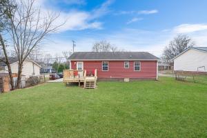 a red house with a playground in a yard at Red Ranch Bring Your Dogs! Fenced Yard in Clarksville