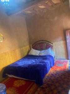 a bedroom with a bed with a blue comforter at Auberge sahnoun in Tafraout +22 photos