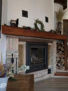 a living room with a fireplace with a wooden mantle at Cortijo la Noria II in Puebla de Don Fadrique