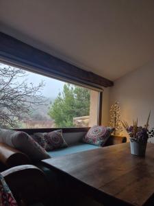 a living room with a table and a large window at Cortijo la Noria II in Puebla de Don Fadrique