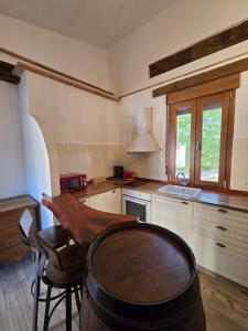a kitchen with a table and a barrel in a room at Cortijo la Noria II in Puebla de Don Fadrique +15 photos