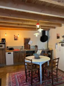 a kitchen with a table and chairs in a room at Labeaume in Labeaume