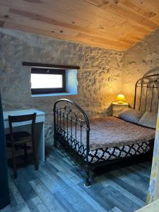 a bedroom with a bed in a stone wall at Labeaume in Labeaume