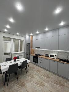 a large kitchen with a table and chairs in it at ЖК Central Park in Aktobe