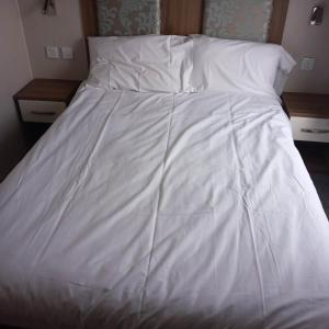 a white bed with white sheets and pillows at The vintage in Winthorpe +4 photos