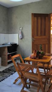 a kitchen with a wooden table with a bowl of fruit at Sol&Mar Paraty Mirim in Paraty