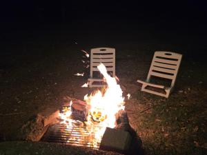 a fire pit with two chairs around it at night at רויאל וואן in Tiberias