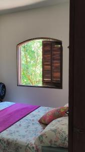 a bedroom with a bed and a window at Sol&Mar Paraty Mirim in Paraty