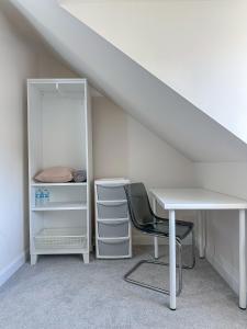 a table and a chair in a room under a attic at The Calm Space Room in Balderton