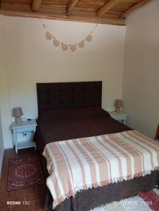 a bedroom with a bed with a striped blanket at Paraíso Serrano in Casa Grande