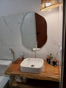 a bathroom with a white sink and a mirror at Casa Refúgio do Rio in Caraíva