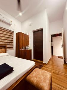 a bedroom with a large bed and a wooden floor at Green Villa Chirackal Gardens in Trichūr