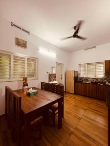 a dining room with a table and a ceiling fan at Green Villa Chirackal Gardens in Trichūr