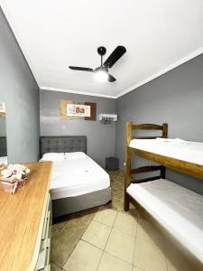 a room with two bunk beds and a desk at Hostel Anprado #3 Kit café incluso, Próx-Aeroporto de Guarulhos in Guarulhos