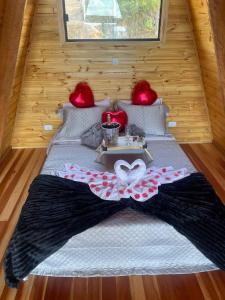 a bed in a tiny house with a table on it at Chalé Colinas in Campos do Jordão