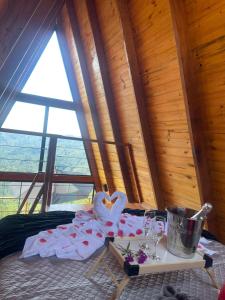 a room with a bed with a table with a tray of towels at Chalé Colinas in Campos do Jordão