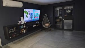 salon z płaskim telewizorem na czarnej ścianie w obiekcie Solid house w mieście Kamionka