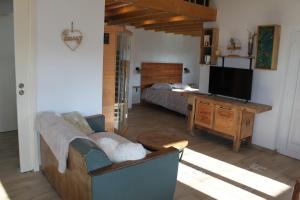 a living room with a couch and a television at L'Effet Mer - Côte D'Albâtre in Saint-Martin-Plage