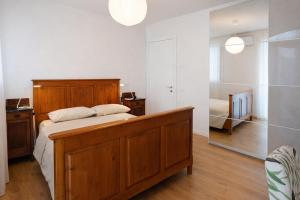 a bedroom with a wooden bed and a mirror at Agriturismo Casa Bregalda in Castelgomberto