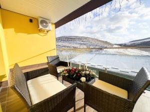 een balkon met stoelen en tafels en uitzicht op het water bij Джерело in Brody