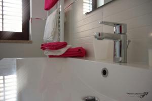 a bathroom sink with a red towel and a faucet at Il Cortiletto in Castelbuono