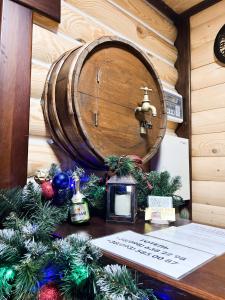 een houten tafel met kerstversieringen en een vat bij Джерело in Brody
