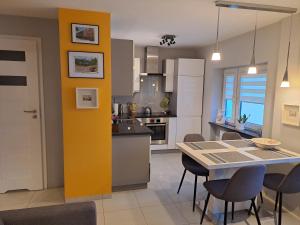 a kitchen and dining room with a table and chairs at Silver Apartament Kowary in Kowary