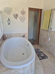 een badkuip in een badkamer met hartjes aan de muur bij Beach House in Pearly Beach +38 foto's