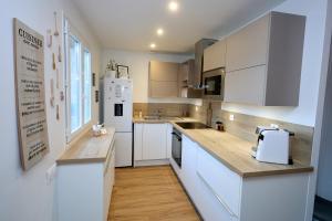a kitchen with white cabinets and a white refrigerator at Maison spacieuse 4 chambres à Bonnard in Bonnard +17 photos