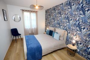 a bedroom with a bed and a blue and white wallpaper at Maison spacieuse 4 chambres à Bonnard in Bonnard