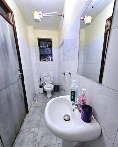 a white bathroom with a sink and a toilet at Euphglory studio in Kakamega
