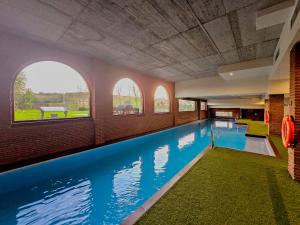 een groot zwembad in een gebouw met ramen bij Apartamentos Estela de Altamira in Santillana del Mar