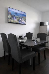 een eettafel met stoelen en een schilderij aan de muur bij ApartDays Sarstedt in Sarstedt +23 foto's