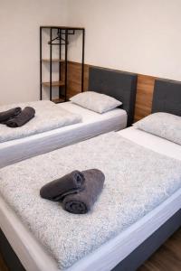 een kamer met drie bedden en handdoeken erop bij ApartDays Sarstedt in Sarstedt