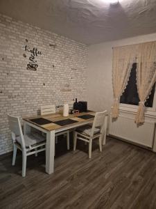 a table and chairs in a room with a brick wall at Inna's and Dima's Ferienwohnung in Pirmasens