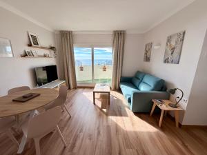 a living room with a blue couch and a table at Kingfisher Apartments Benal Beach in Benalmádena