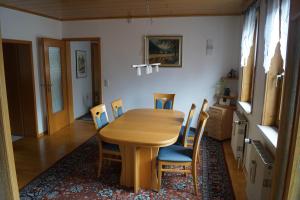 a dining room with a wooden table and chairs at Ferienhaus Am Arzberg in Kurort Steinbach-Hallenberg