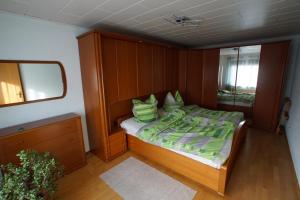 a small bedroom with a bed and a mirror at Ferienhaus Am Arzberg in Kurort Steinbach-Hallenberg