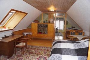 a bedroom with a bed and a desk in a attic at Ferienhaus Am Arzberg in Kurort Steinbach-Hallenberg