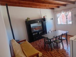 een eetkamer met een tafel en stoelen en een open haard bij wind house - casa del viento in Perito Moreno
