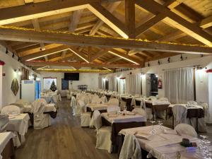een grote feestzaal met witte tafels en stoelen bij Park Hotel Serenissima in Sacrofano